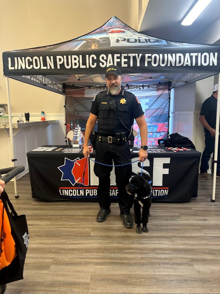 Law enforcement officer and service dog at a Lincoln Public Safety Foundation memorial event booth