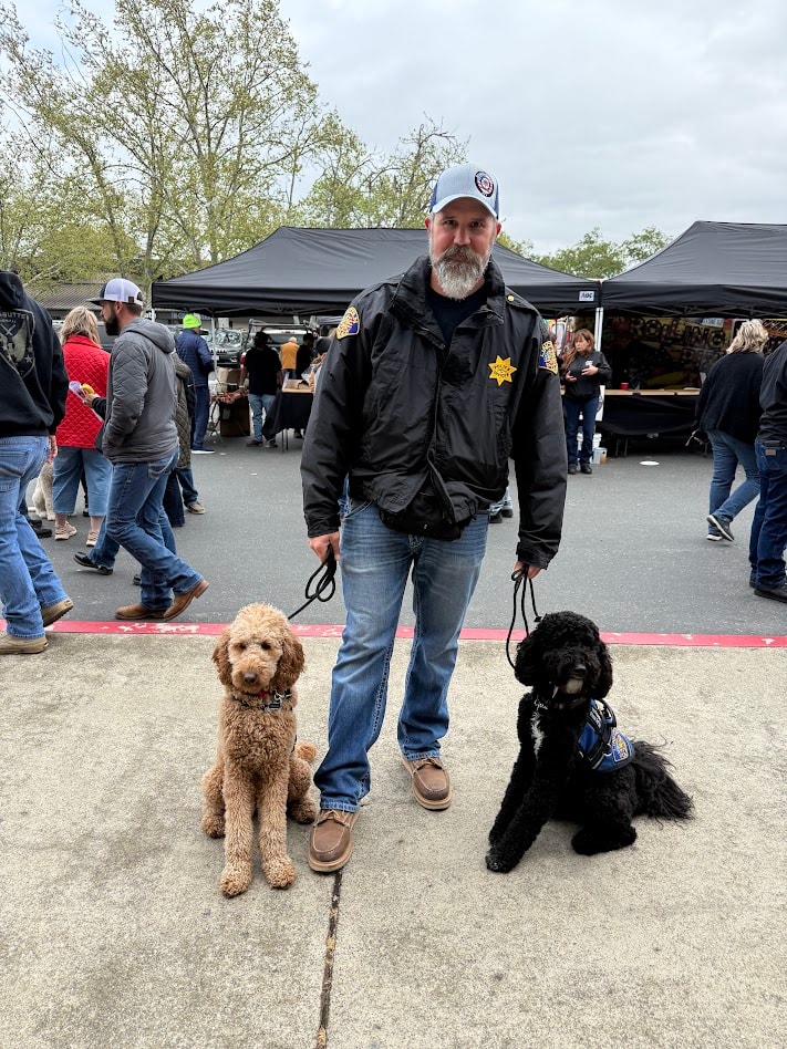 Law enforcement officer with two service dogs at a memorial event